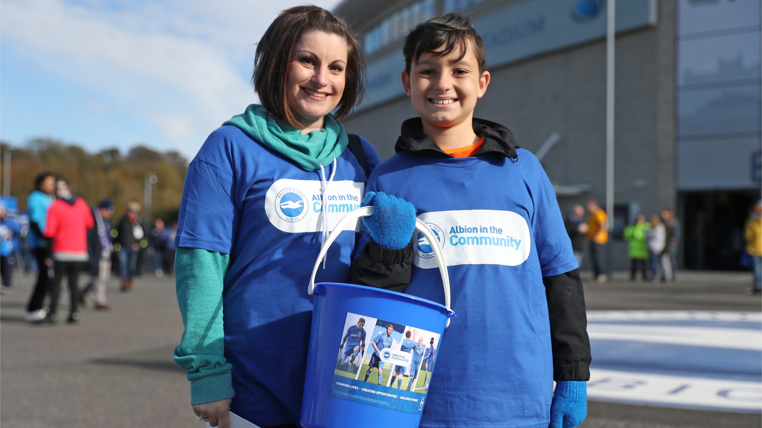 woman and boy holding a donation bucket