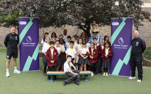 The children of St Bartholomew's school posing with Dirar, Gully, and their teachers and tutors outside under a tree