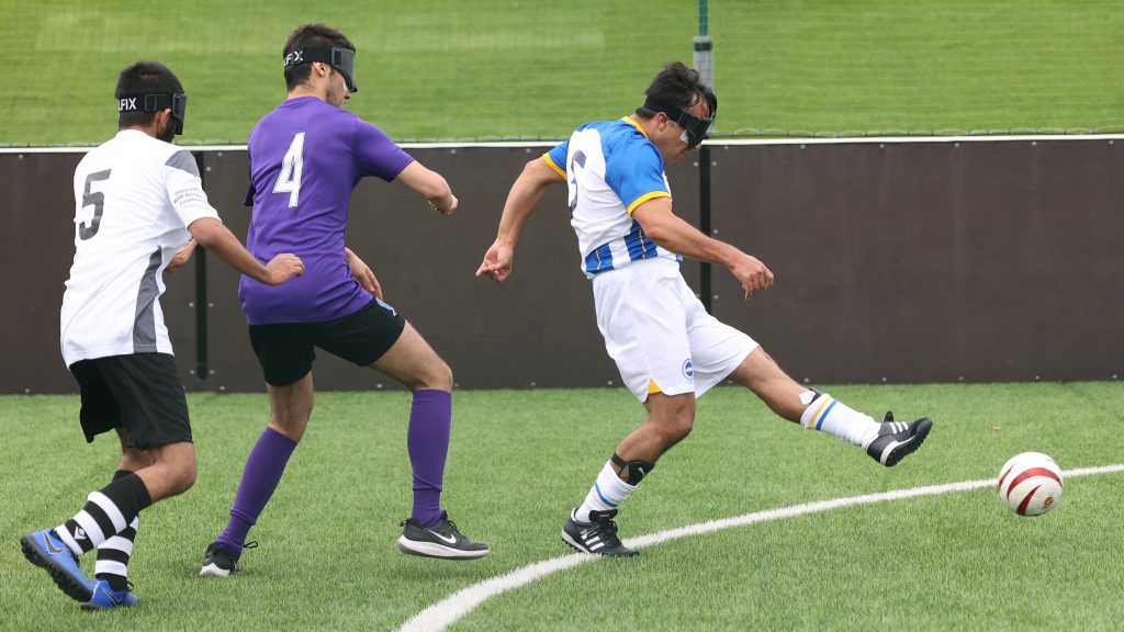 An Albion player strikes the ball as two defenders try to stop him