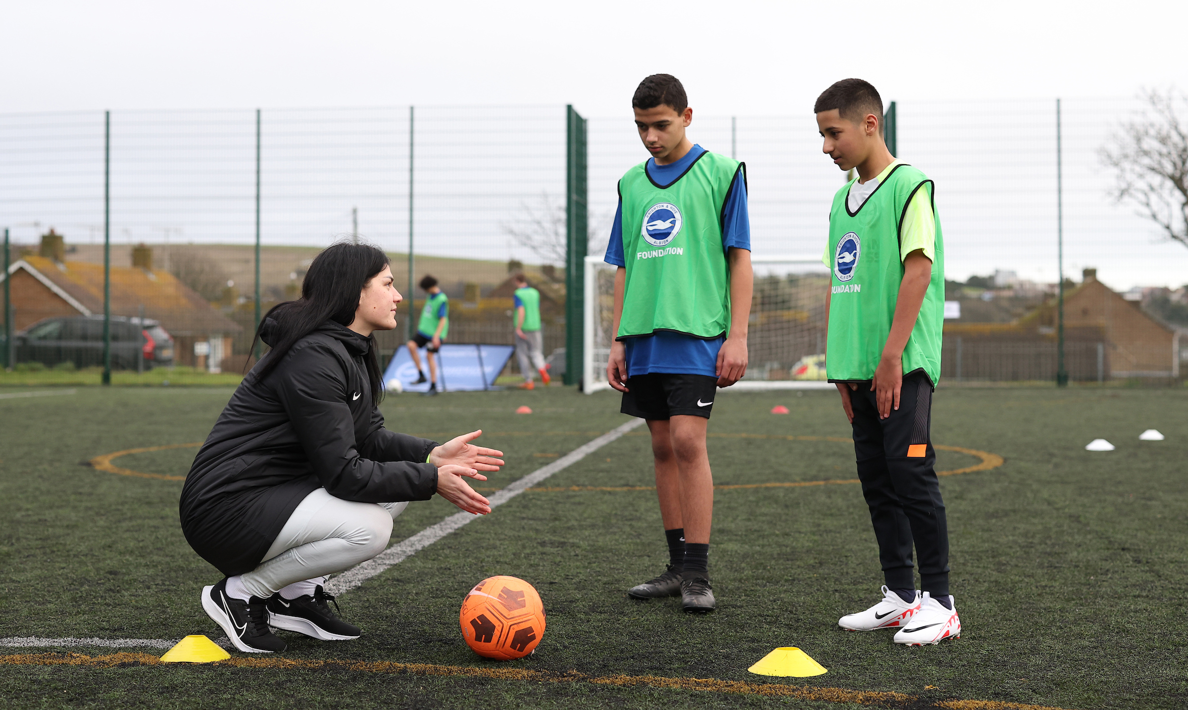 Dejana Stefanovic crouches to talk to two youngsters in BHAFC bibs.