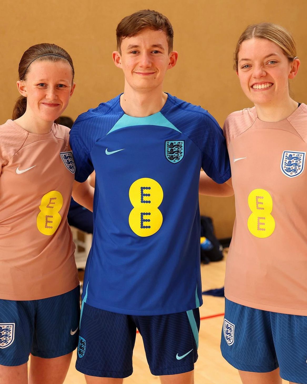 Jake, Faye, and another female player pose for a photo together in a sports hall.